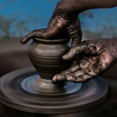 Artisan shaping a clay pot on a potter's wheel