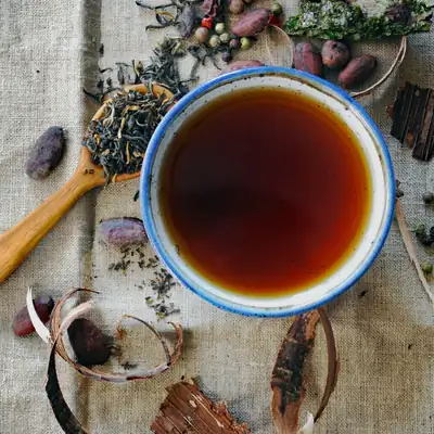 Bowl of brewed tea with loose tea leaves on cloth