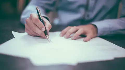 Hand signing a trade contract with a pen