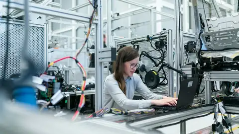 Engineer checking production equipment on a factory floor